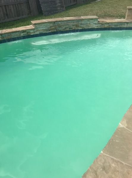 Cloudy green pool water with a stone spillway before ozone purification